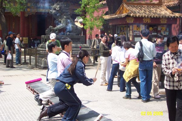 Paying homage to Buddha with burning Incense
Many visitors to the Lama Temple bought incense to the Temple and then lit three sticks bowing to the Buddha three times before setting the incense into the "pot" to continue burning. There were many incense  sellers outside the Temple. 
