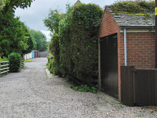 A view of the outer driveway with the Godwins' garage
The photograph shows how the conifer hedge (on the right, just past the garage) overhangs our property.
Schlüsselwörter: Drive Driveway Whitecroft confier