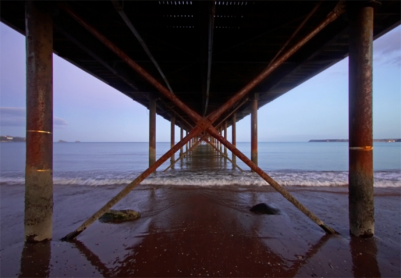 Paignton Pier -- From Below
[url=http://www.paigntonpier.co.uk]Paignton Pier[/url] is described on its website as a "five star attraction."   Hmmm.  I'm not so sure I'd go that far, but it looked quite "moody" when we walked beneath it at twilight, in mid-January.
Keywords: Paignton Pier Torbay Torquay waves twilight