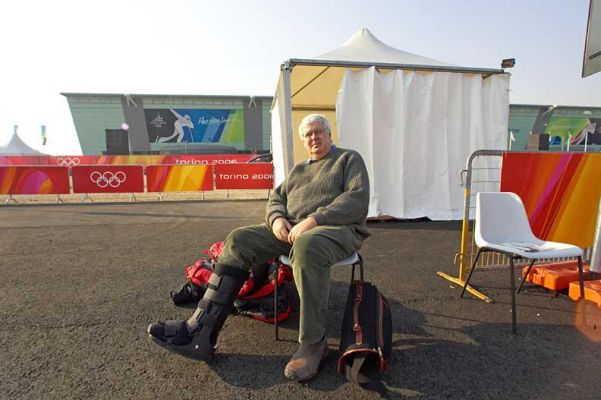 Me Sitting on a Chair Outside the Oval Lingotto
We went to see the speed skating at the new Oval Lingotto.  This was the first place where the Caribineri (police) actually let me get through to the handicapped parking area with my EU handicapped parking permit.  I sat on this chair in the parking lot until they brought around an electric cart a few minutes later.
الكلمات الإستدلالية(لتسهيل البحث): Oval Lingotto speed skating Olympics Torino Craig