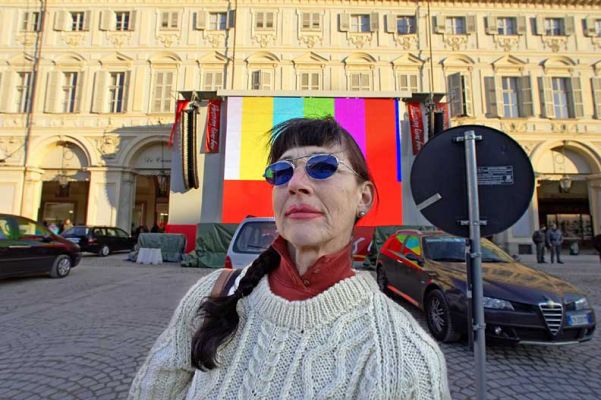 Marjorie in the Piazza San Carlo
The day before the Opening Ceremony of the Olympics.  NBC had an outdoor television studio near-by (for the Today Show), hence there was this big TV screen.  We had lunch at the Cafe San Carlo -- it was so horrible that we sent it back.  The young couple at the table near us, from Malta, had the same problem.  When in Torino, avoid the Cafe San Carlo!
Anahtar kelimeler: Cafe San Carlo Piazza San Carlo Marjorie Today Show NBC jumbo TV screen Torino Turin Italy