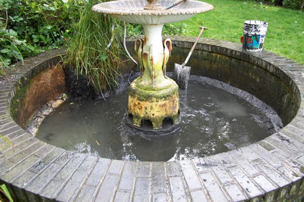 Repairing the Fountain
Giving the fountain in the front garden a good clean.  Unfortunately, in doing this the young lad managed to remove all of the moss from the outside of the fountain, and kill all of the plants in the front.  The fountain looks "new" again, but has lost the patina it took a dozen years to acquire.  October 2 2006
Keywords: fountain Whitecroft front garden repair clean mud