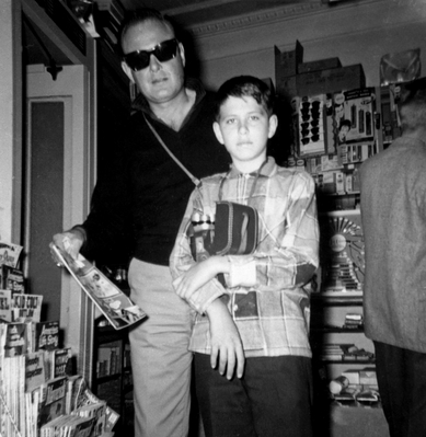 A Father And Son Moment
My father, John Walsh, buying me a comic book.  Somewhere on our trip to the East Coast, April 1960.  Ever the cinematographer, I have a movie camera around my neck.  And my father looks like a Blues Brother.
Anahtar kelimeler: comic book craig walsh john walsh