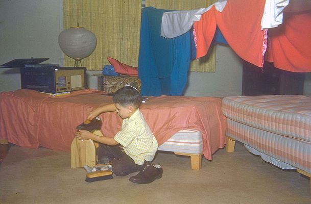Shoe Shine Boy
Baba (my maternal grandfather) loved to build make-believe forts for me, using rope and blankets.  Here I am with a fort, but I seem to be preoccupied with the shining of shoes.  I think the radio (is that what it is?) in the background is amazing.
Ključne besede: radio fort shoe shine Craig Baba