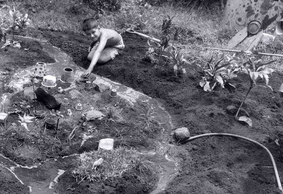 Craig in the Model Village - at 140 Dowsett Avenue
Playing in the back garden at 140 Dowsett Avenue in Nuuanu, creating my own little "model village," 1958.  I can remember painting the clay pots to look like houses, and (of course) there was the obligatory running water.  Didn't take long for it to turn into mud.
Keywords: Craig model village mud 140 Dowsett Avenue Baba mud water ti leaves