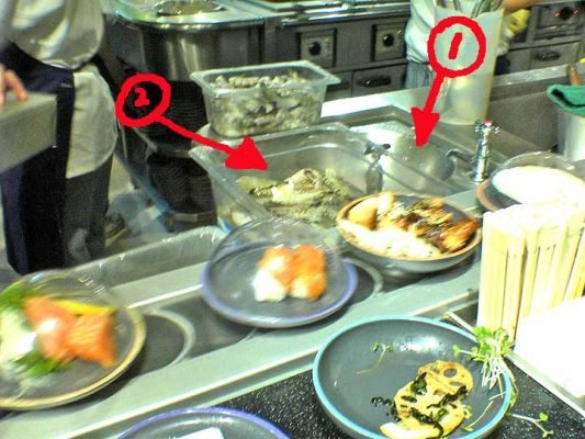 Selfridge's Sushi Bar - Birmingham
The view from our seat.  The gentleman washed his hands in the sink (arrow 1) and dried them by shaking them off.  The water --- seen as drops on the stainless steel sink --- went into the shrimp he was peeling (arrow 2).
Keywords: Selfridges Birmingham sushi shrimp