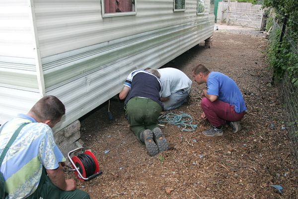 Reminds me of the old joke about light bulbs...
We've purchaed a caravan trailer to provide temporary housing for our two new colleagues from Poland.  It was quite a drama getting it down the Whitecroft driveway.  The gentleman from the caravan company came out a couple of days ago to look at the driveway and he said it was "fine."  There were some tense moments, particularly with our neighbour.  Here are the guys trying to find the electrical socket.
Ključne besede: trailer Poland caravan